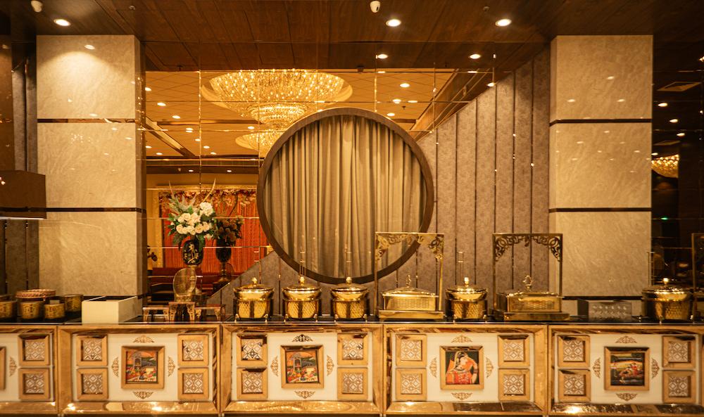 Long buffet spread with chafing dishes and fresh décor inside Ramayan Banquet hall