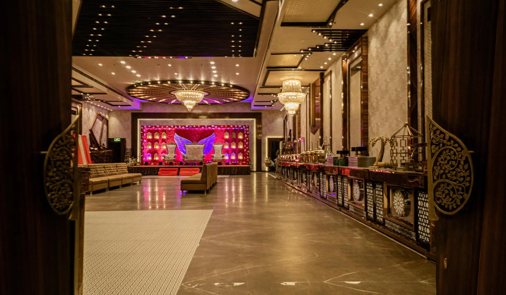 Wide-angle view of Swayamvar Banquets’ elegant indoor hall in Kolkata with round tables and luxurious chandeliers